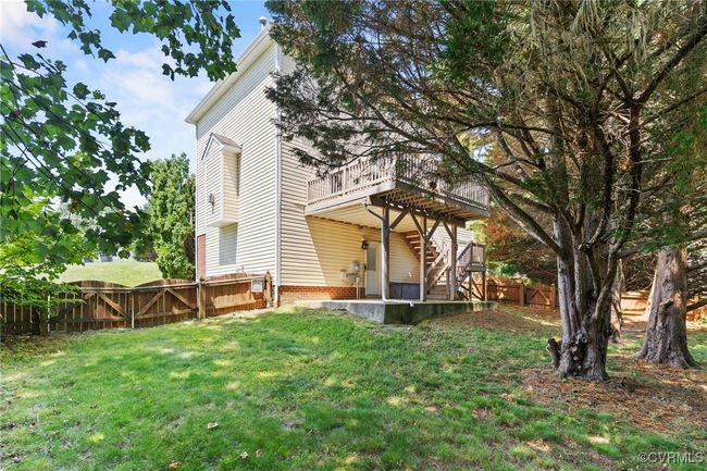 Rear view of house featuring a wooden deck, a fenced backyard, and stairway | Image 33