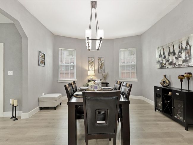 Dining room with light wood finished floors, arched walkways, baseboards, and a chandelier | Image 15