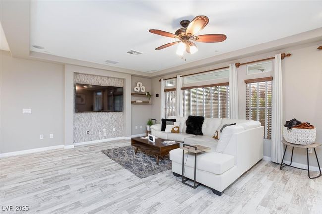Living room featuring wood finished floors, visible vents, a ceiling fan, and baseboards | Image 10