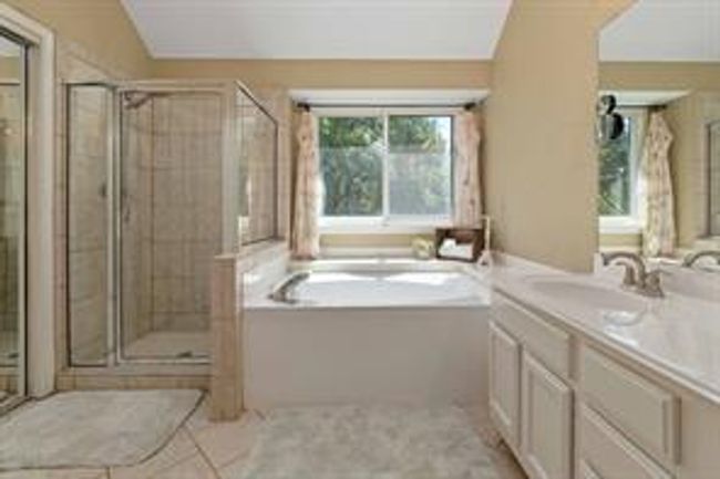 Bathroom with a stall shower, vanity, and a garden tub | Image 27