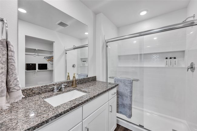 Full bath featuring recessed lighting, vanity, visible vents, a shower stall, and a walk in closet | Image 14