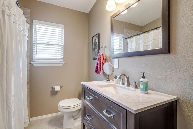 Bathroom with vanity, tile patterned floors, and a shower with curtain | Image 17