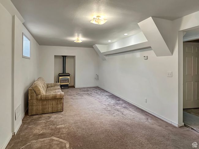 Unfurnished room with a wood stove, carpet floors, and baseboards | Image 20