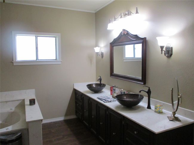 Bathroom featuring a healthy amount of sunlight, wood-type flooring, double sink vanity, and crown molding | Image 33