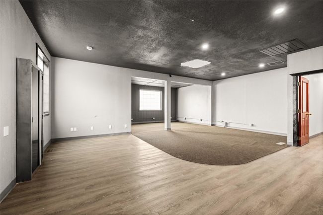 Basement with wood finished floors, recessed lighting, and a baseboard heating unit | Image 47