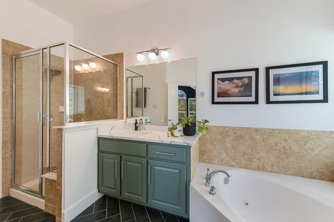 Full bath featuring a whirlpool tub, a shower stall, vanity, and tile patterned flooring | Image 18