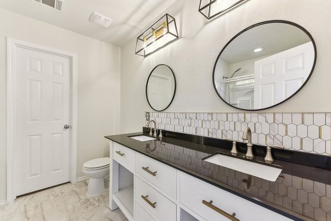 Bathroom with marble finish floor, visible vents, a sink, and toilet | Image 20