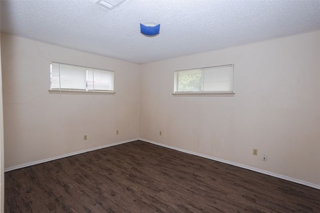 Unfurnished bedroom with wood finished floors and a textured ceiling | Image 11