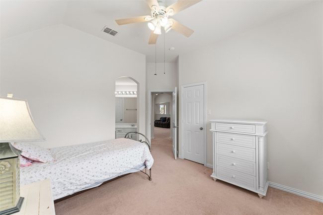 Bedroom with arched walkways, light colored carpet, a ceiling fan, ensuite bath, and lofted ceiling | Image 28