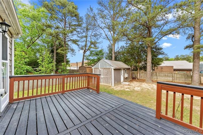 Wooden deck with a storage unit, a fenced backyard, a yard, and an outdoor structure | Image 27