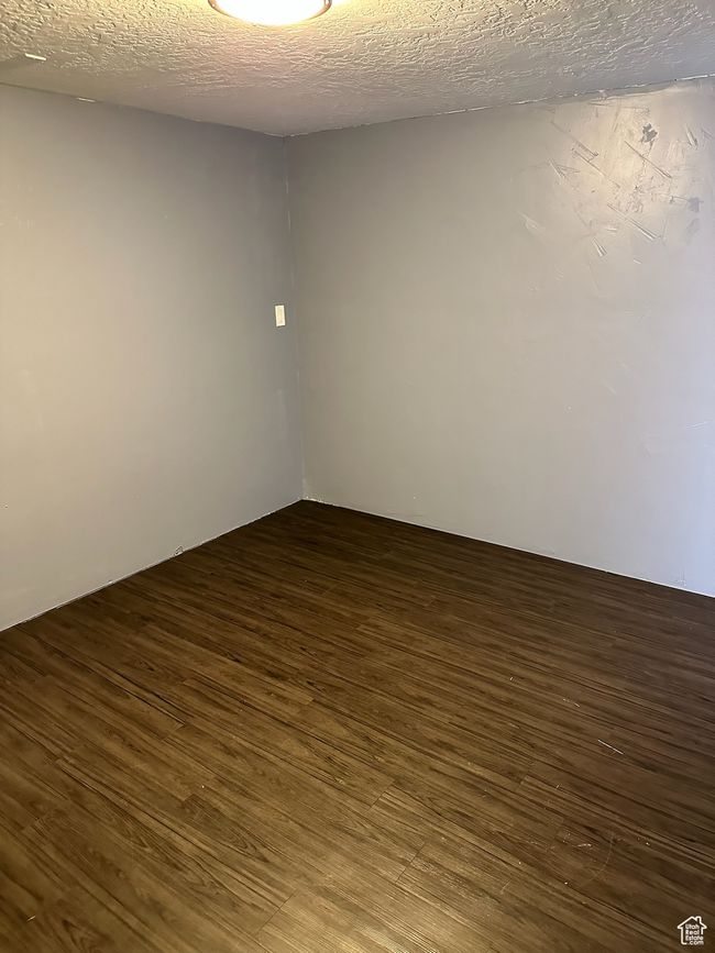 Empty room featuring a textured ceiling and dark wood-type flooring | Image 20