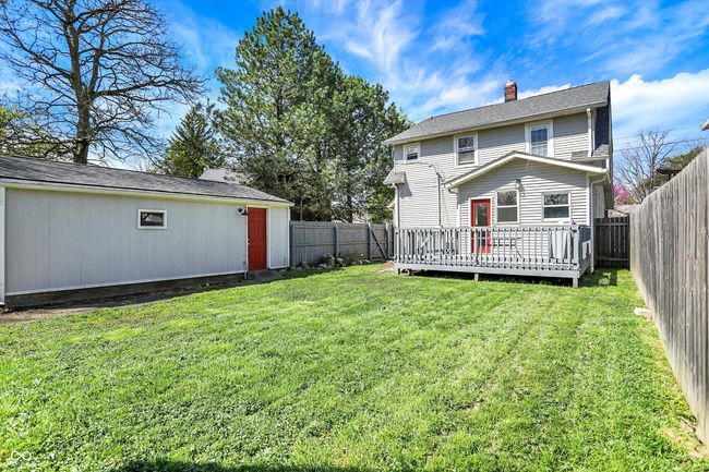 back of property featuring a wooden deck, a fenced backyard, a chimney, and a yard | Image 40