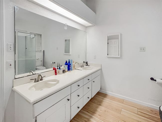 Full bathroom featuring wood finished floors, double vanity, and a shower with door | Image 8