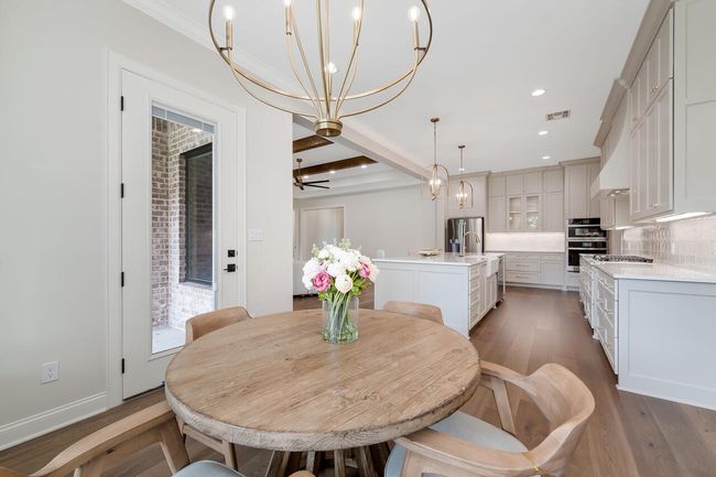 Dining room featuring a chandelier, wood finished floors, beamed ceiling, recessed lighting, and ceiling fan | Image 20