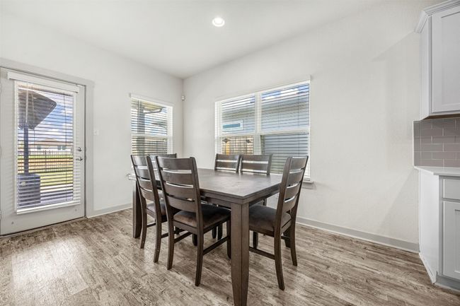 The bright and airy dining space, offering ample room for a large table and direct access to the private backyard through a glass door. | Image 9