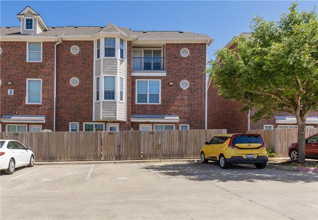 View of building exterior with uncovered parking and fence | Image 10