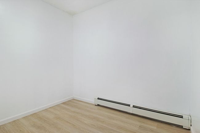 Spare room featuring a baseboard heating unit, wood finished floors, and baseboards | Image 27