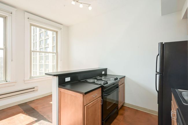 Sleek black countertops and appliances. | Image 11