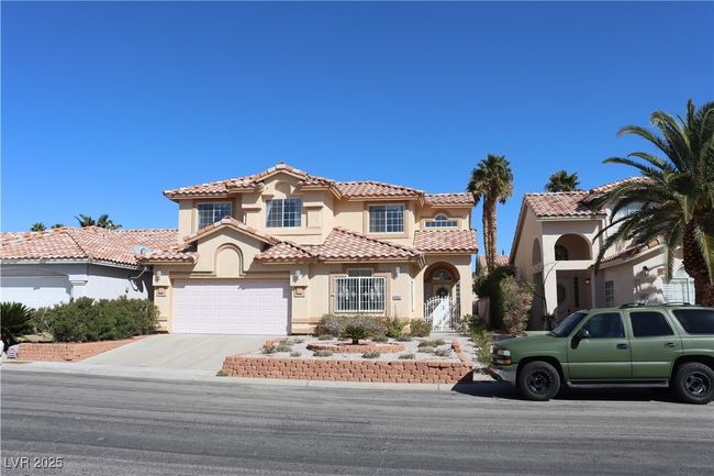 Mediterranean / spanish-style house with stucco siding, concrete driveway, a garage, and a tiled roof | Image 5