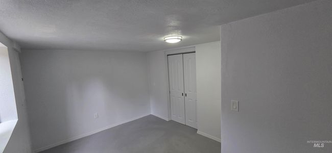 Spare room with a textured ceiling and concrete flooring | Image 14
