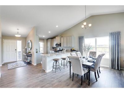 The home features a great kitchen/dining area, which is large enough to accommodate just about any table and resides directly under the peak of a cathedral vault that hovers over the entire main level. Photo of model home, colors will vary. | Image 1