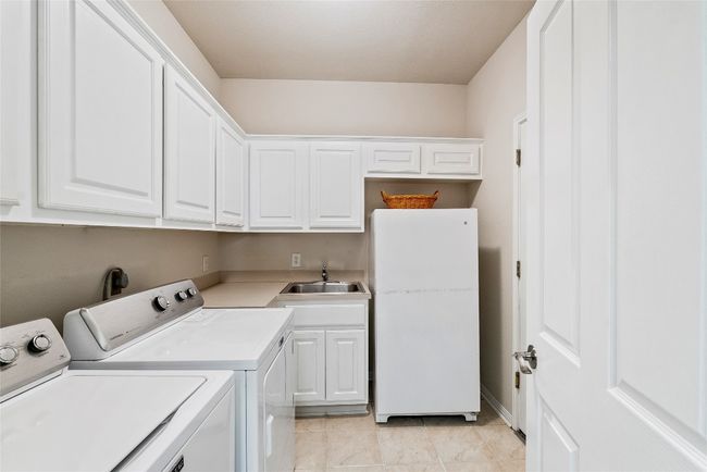 Large laundry room with built-in cabinetry and a utility sink | Image 29