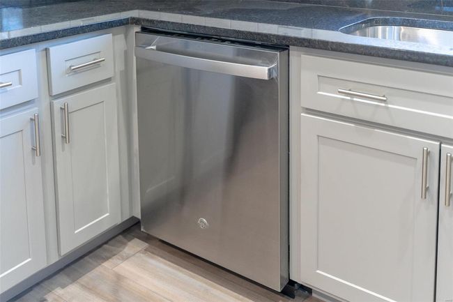 Details featuring stainless steel dishwasher, gray cabinets, and light / wood-style flooring | Image 50