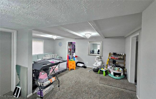 Playroom with a textured ceiling, baseboards, and carpet floors | Image 16