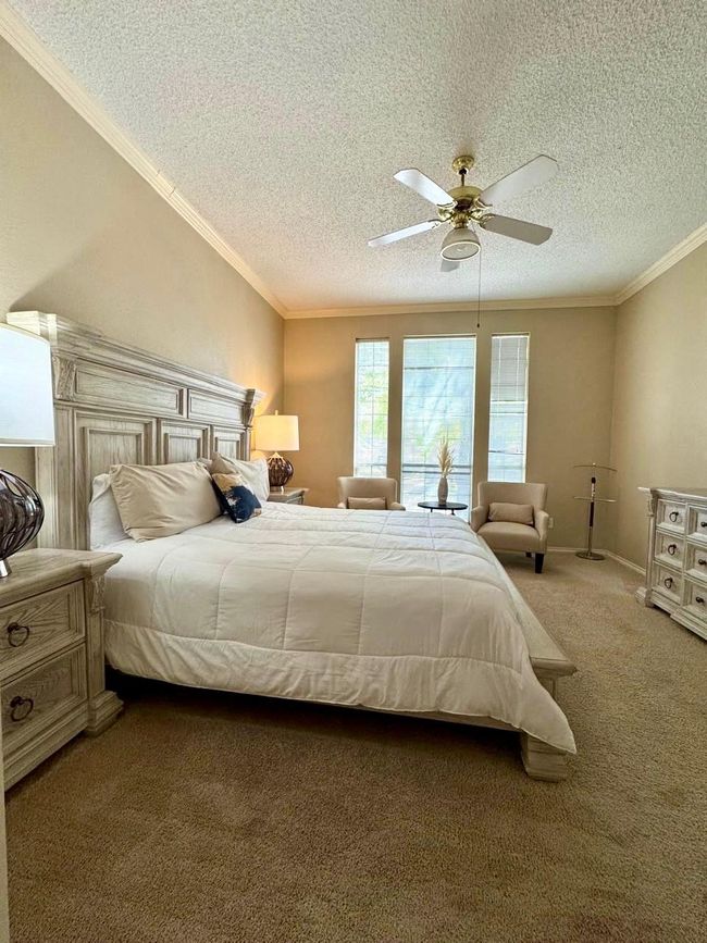 Bedroom featuring carpet flooring, a textured ceiling, crown molding, and ceiling fan | Image 10