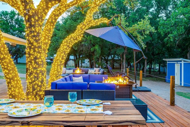 Wooden terrace with an outdoor structure, an outdoor living space with a fire pit, outdoor dining area, and a storage shed | Image 33