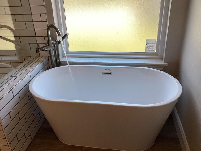 Bathroom view of a freestanding tub and wood finished floors | Image 21