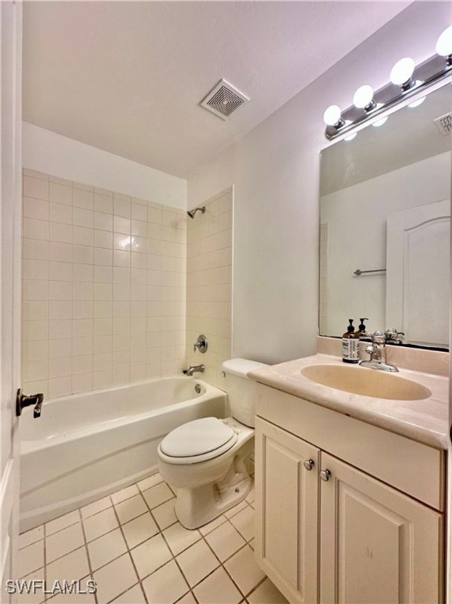 Full bathroom with tile patterned flooring, vanity, toilet, and tiled shower / bath | Image 17