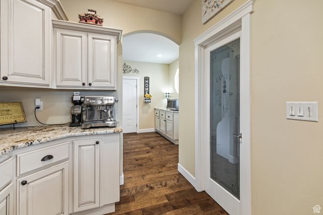 Kitchen with white cabinets, dark hardwood / wood-style floors, and light stone countertops | Image 38