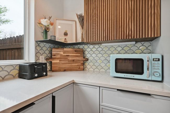 Sleek quartz countertops and unique backsplash add to the allure. | Image 13