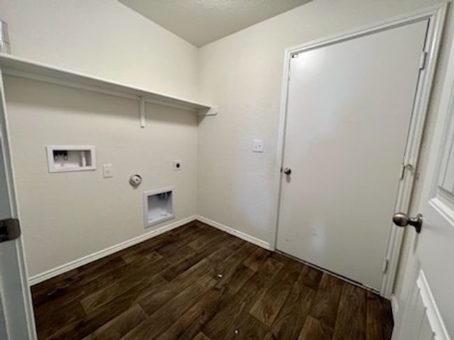 Laundry room with dark wood-type flooring, hookup for an electric dryer, hookup for a washing machine, and gas dryer hookup | Image 19