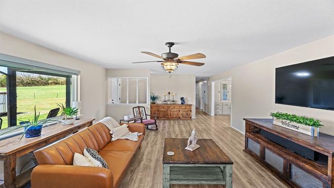 Living area with light wood finished floors and a ceiling fan | Image 25