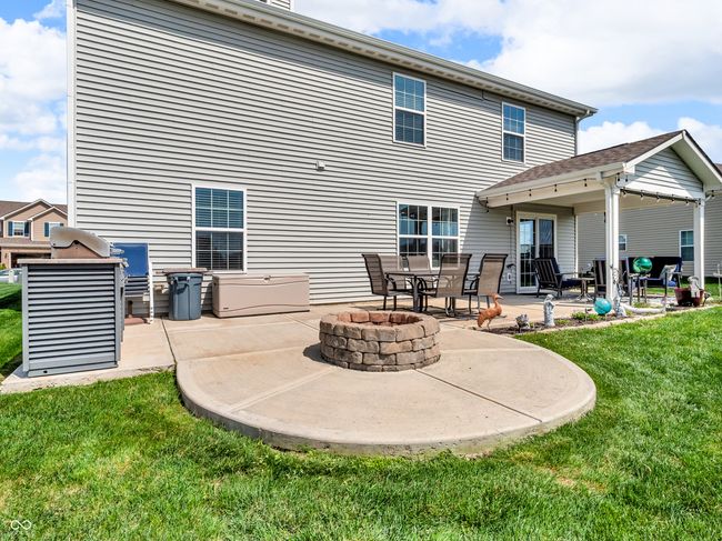 rear view of property with a lawn, an outdoor fire pit, and a patio area | Image 44