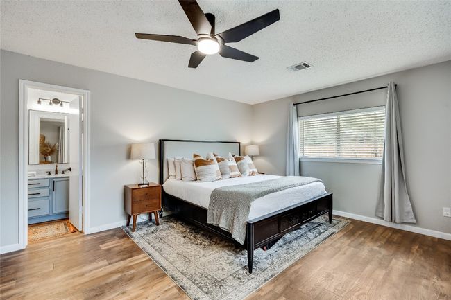 Bedroom with light wood-style flooring, a textured ceiling, baseboards, a sink, and ceiling fan | Image 21