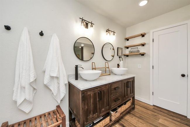 This bathroom blends rustic charm with modern elegance—farmhouse-inspired finishes create a warm, inviting feel. | Image 18