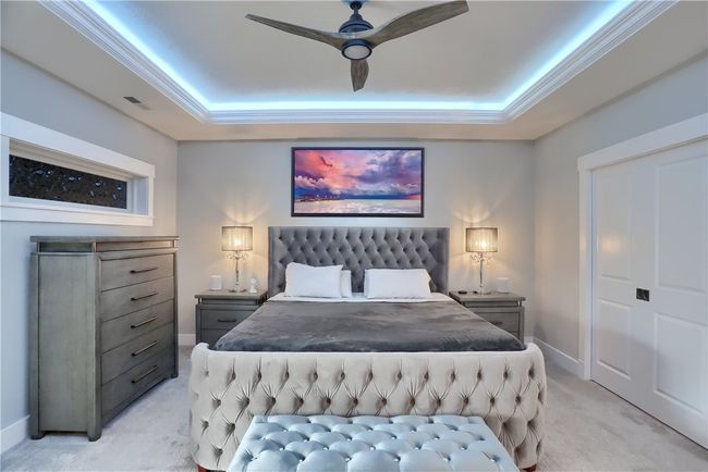 A sculptural, modern chandelier adds a dramatic design moment above the stairwell, beautifully framed by sleek black railings and soft ambient lighting. | Image 27
