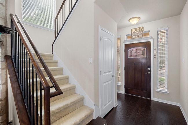 The stairway opens to the main living area with wrought iron balusters and smooth wood railings. | Image 17
