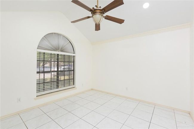 Spare room featuring vaulted ceiling, light tile patterned floors, baseboards, and ceiling fan | Image 6