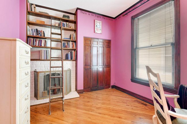 A second fireplace gives this room such a cozy vibe! The library ladder provides charming and easy access to the built-in bookshelves. | Image 19