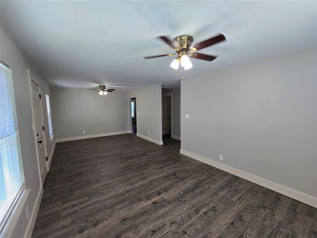Spare room featuring ceiling fan, dark wood-style flooring, and healthy amount of natural light | Image 5