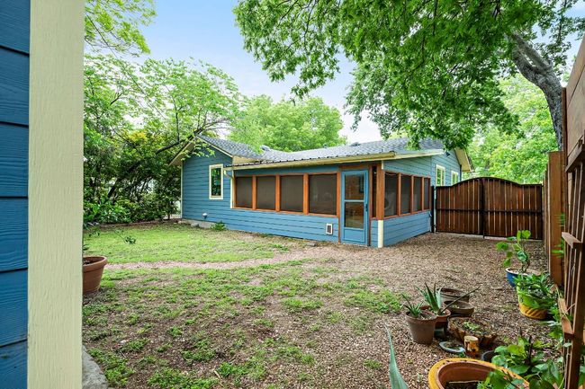 Rear view of house featuring a gate to the driveway and huge screened in back porch. | Image 38
