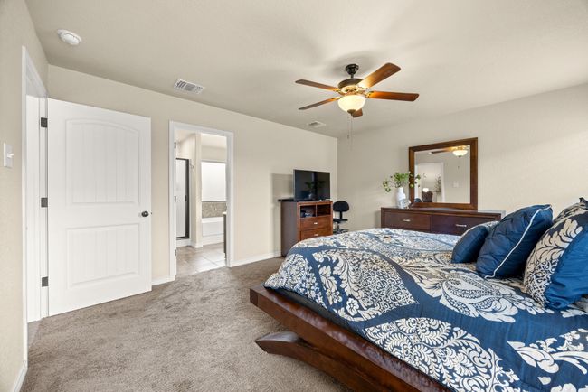 Carpeted bedroom with ceiling fan and ensuite bath | Image 16