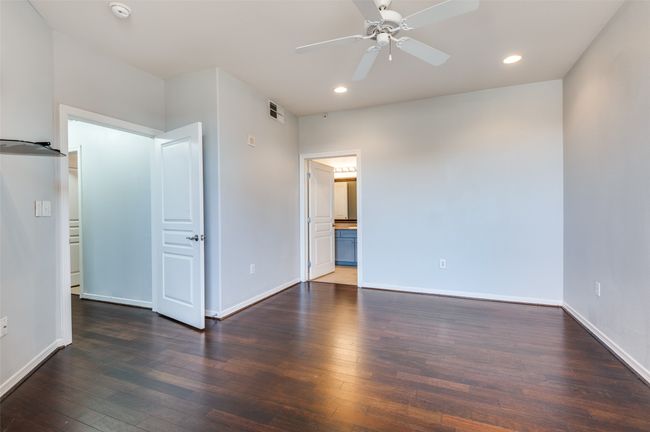 Dark hardwood flooring in primary bedroom with loads of natural light. | Image 11