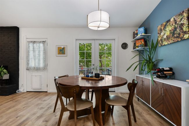Dining space with a fireplace, light wood-type flooring, and french doors | Image 12