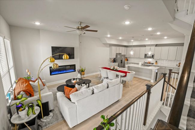 Living room featuring a glass covered fireplace, ceiling fan, recessed lighting, and light wood-style flooring | Image 6