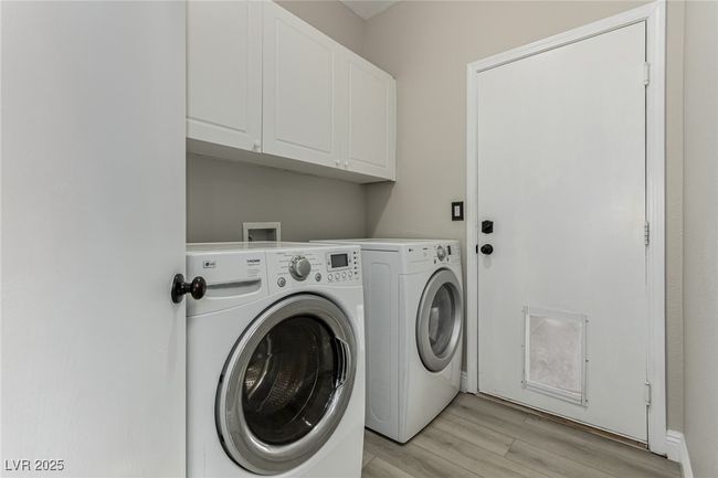 Clothes washing area featuring cabinet space, light wood-type flooring, and independent washer and dryer | Image 28